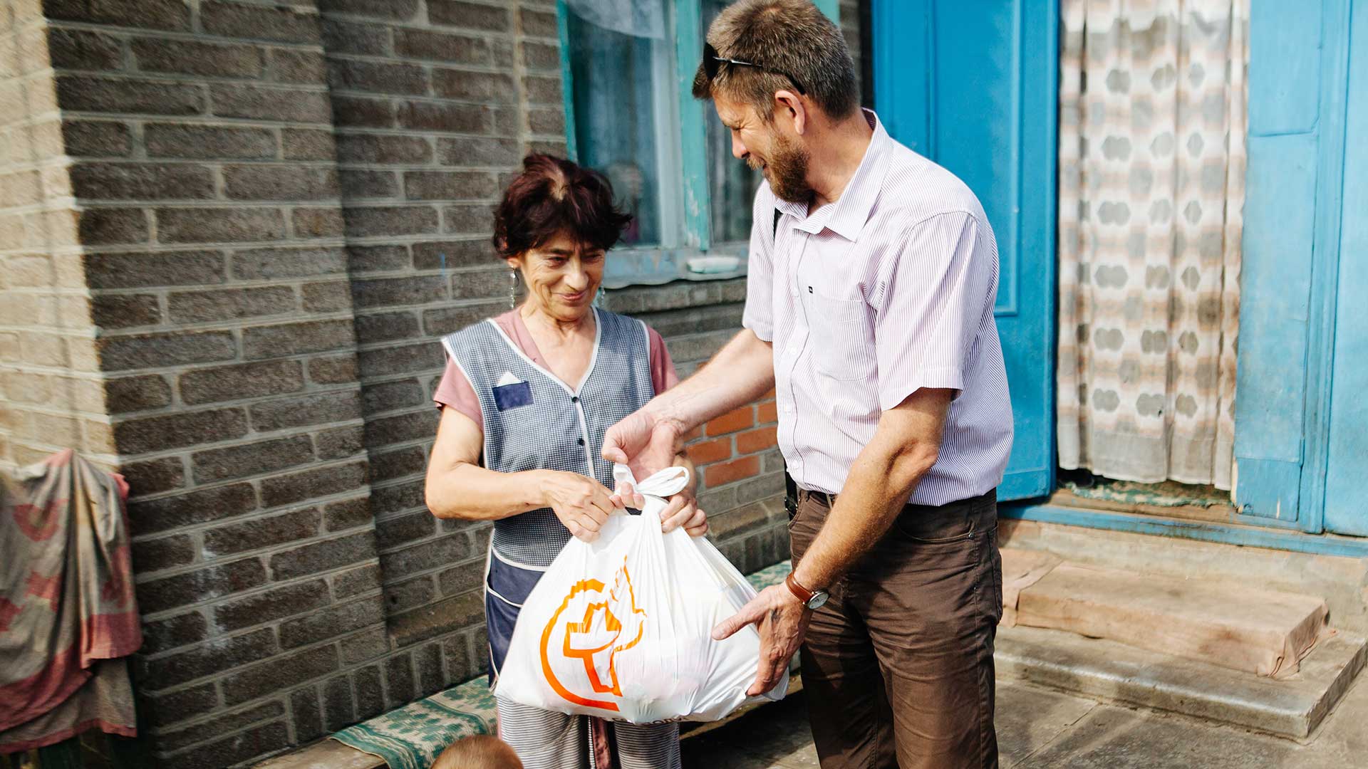 A family receives a bag of supplies, Ukraine